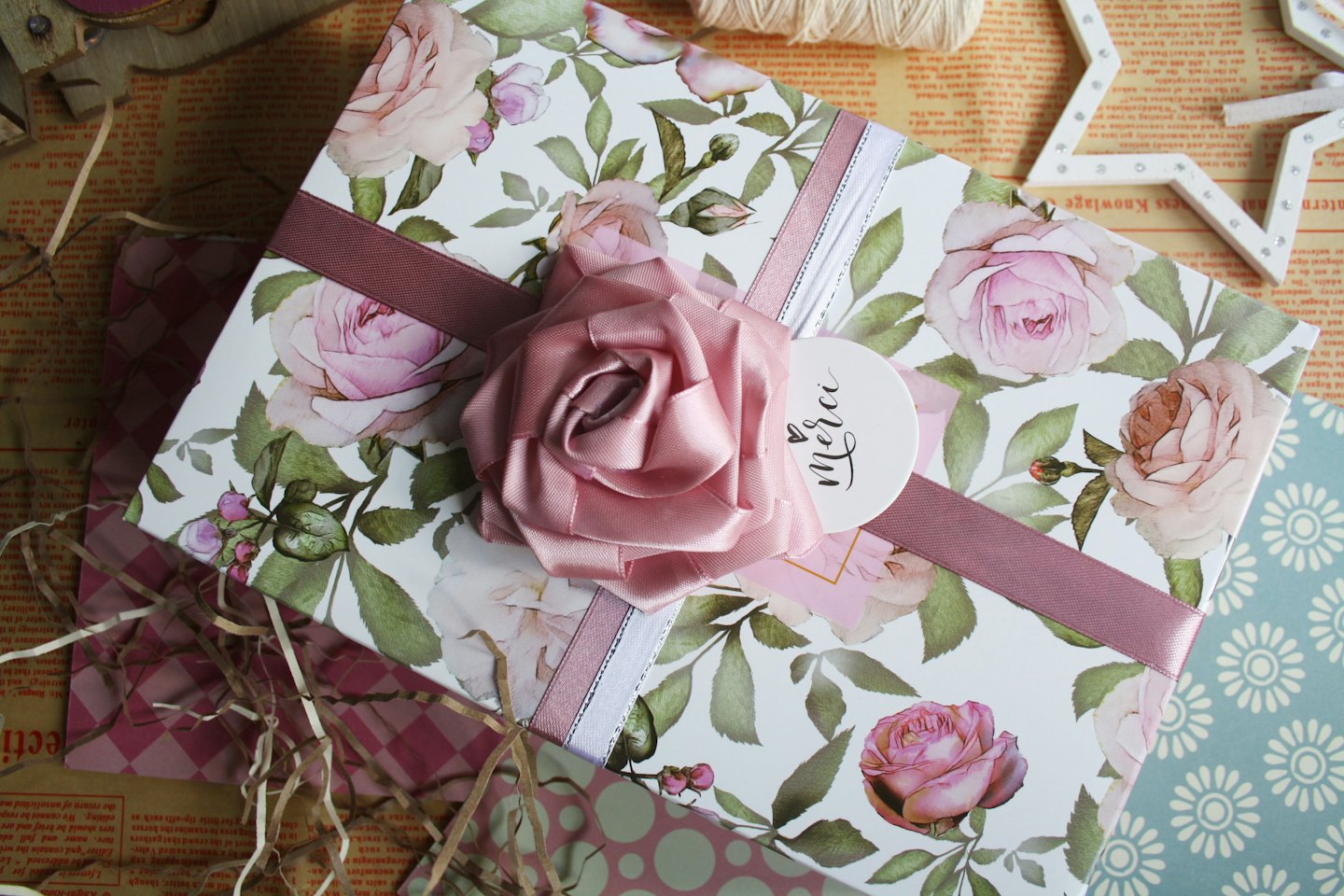 Wrapped gift box decorated with flowers and ribbons on textured paper.