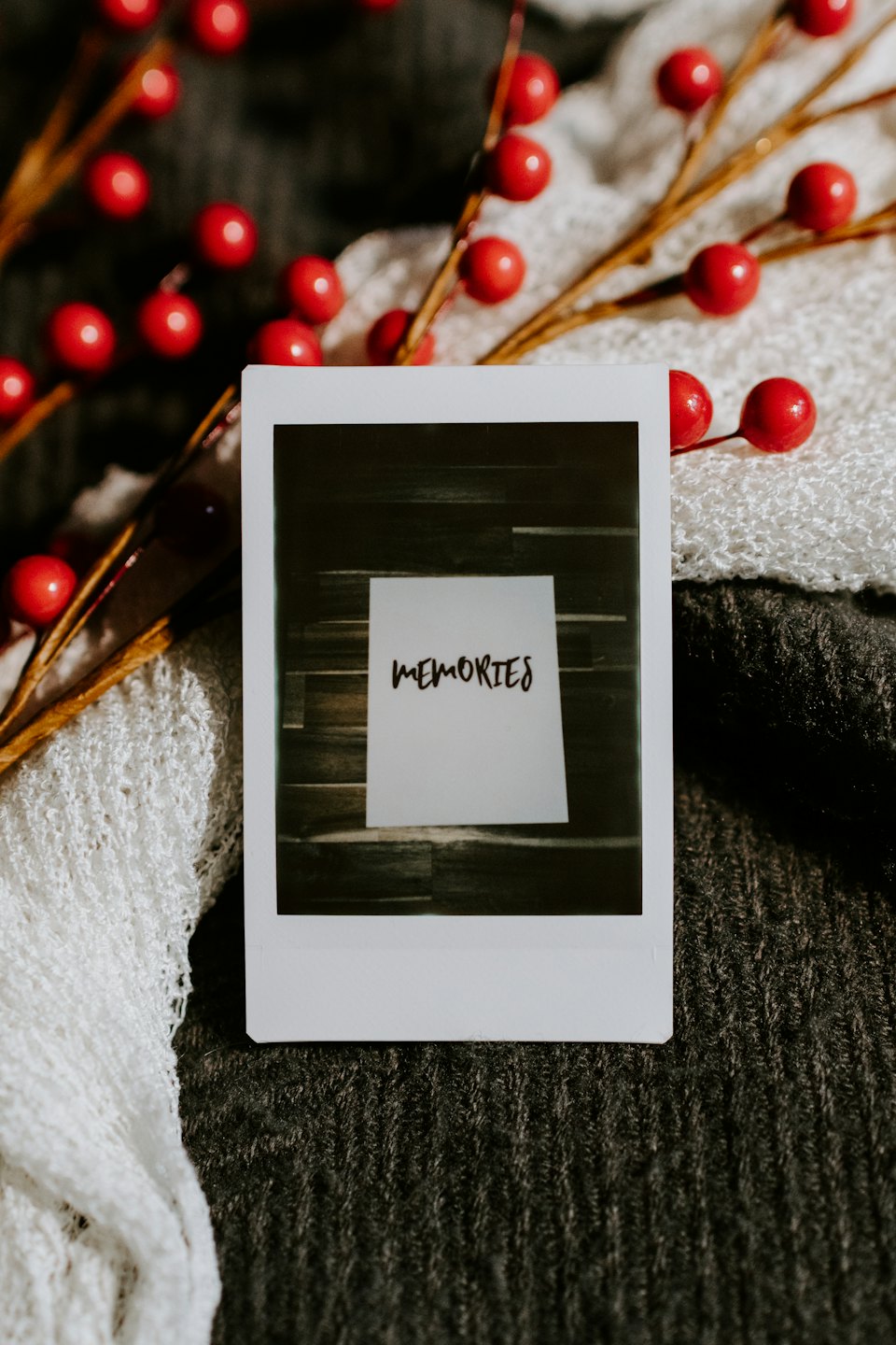 Instant photo print with 'MEMORIES' on a grey knit surface.